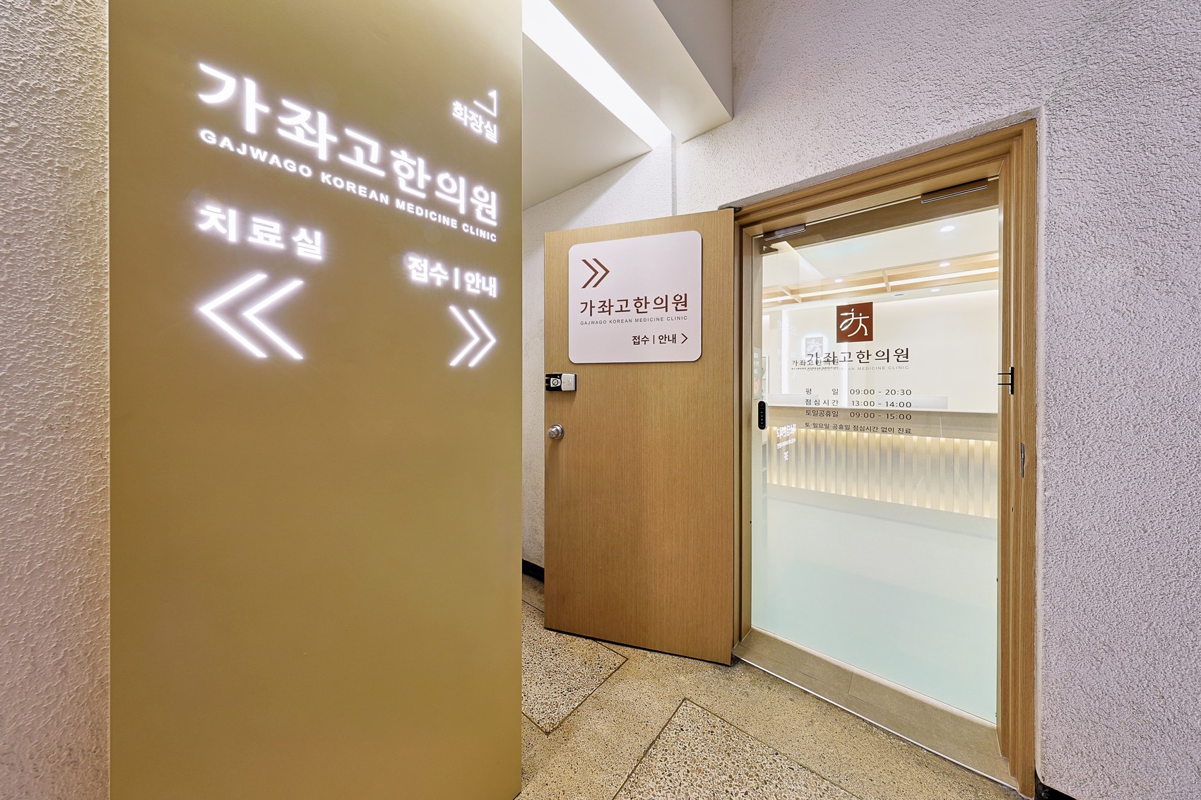 한의원 출입구 유리문과 안내 사인