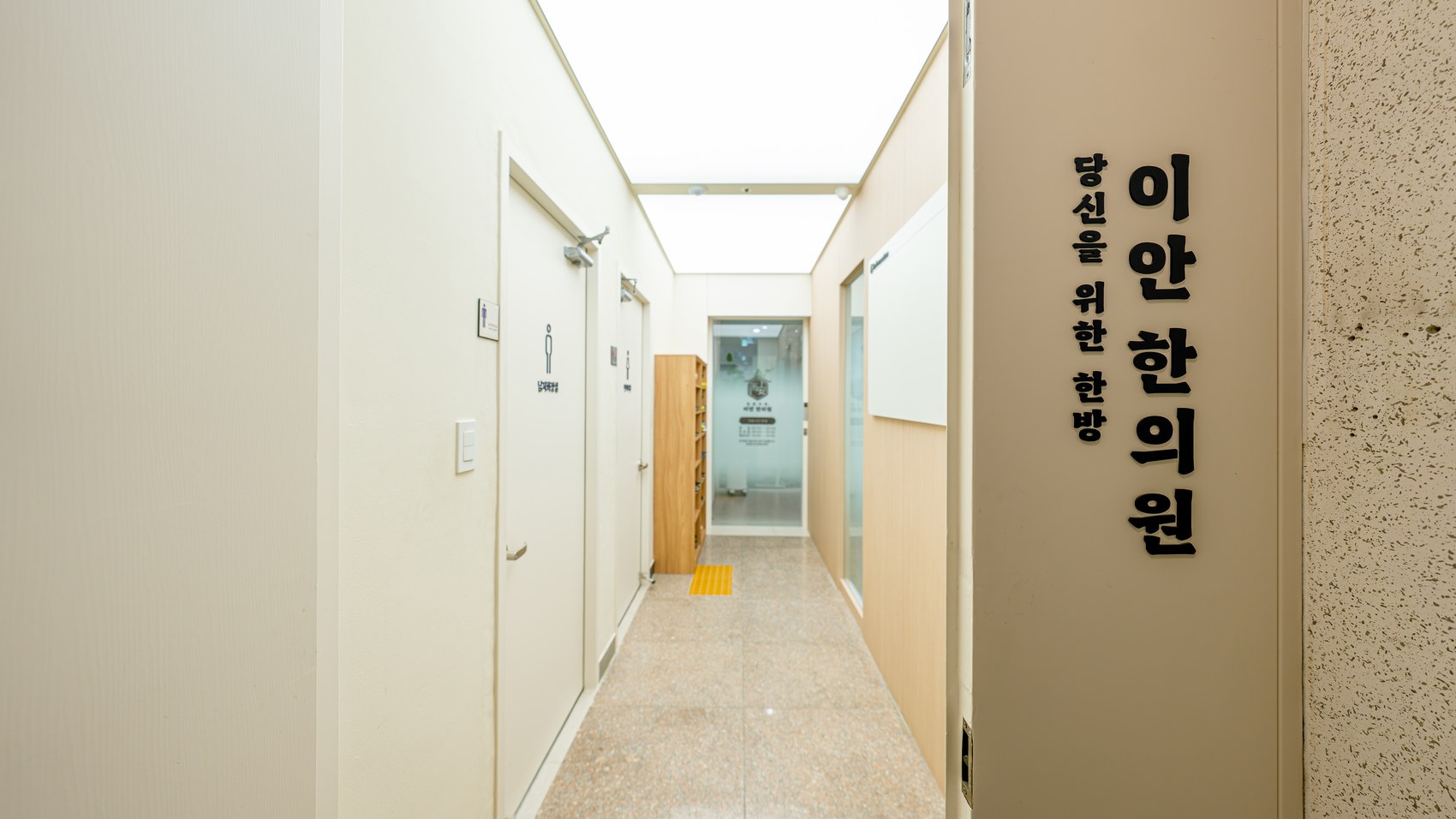 한의원 입구 복도와 사인 벽